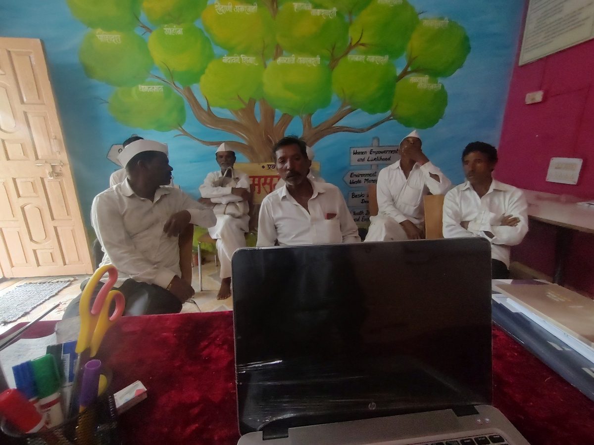 Farmers in a meeting room discussing government schemes with AgriCare