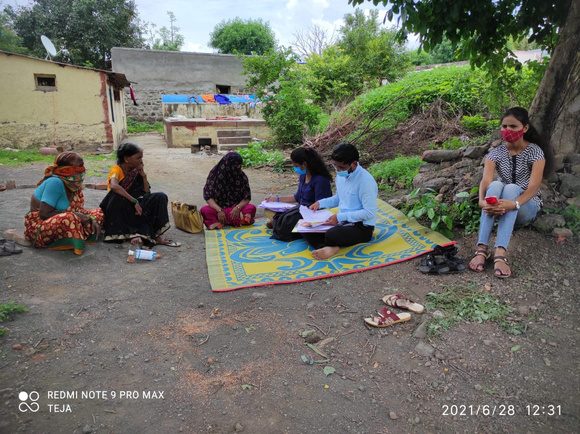 Sakhi program team meeting with a group of women outdoors