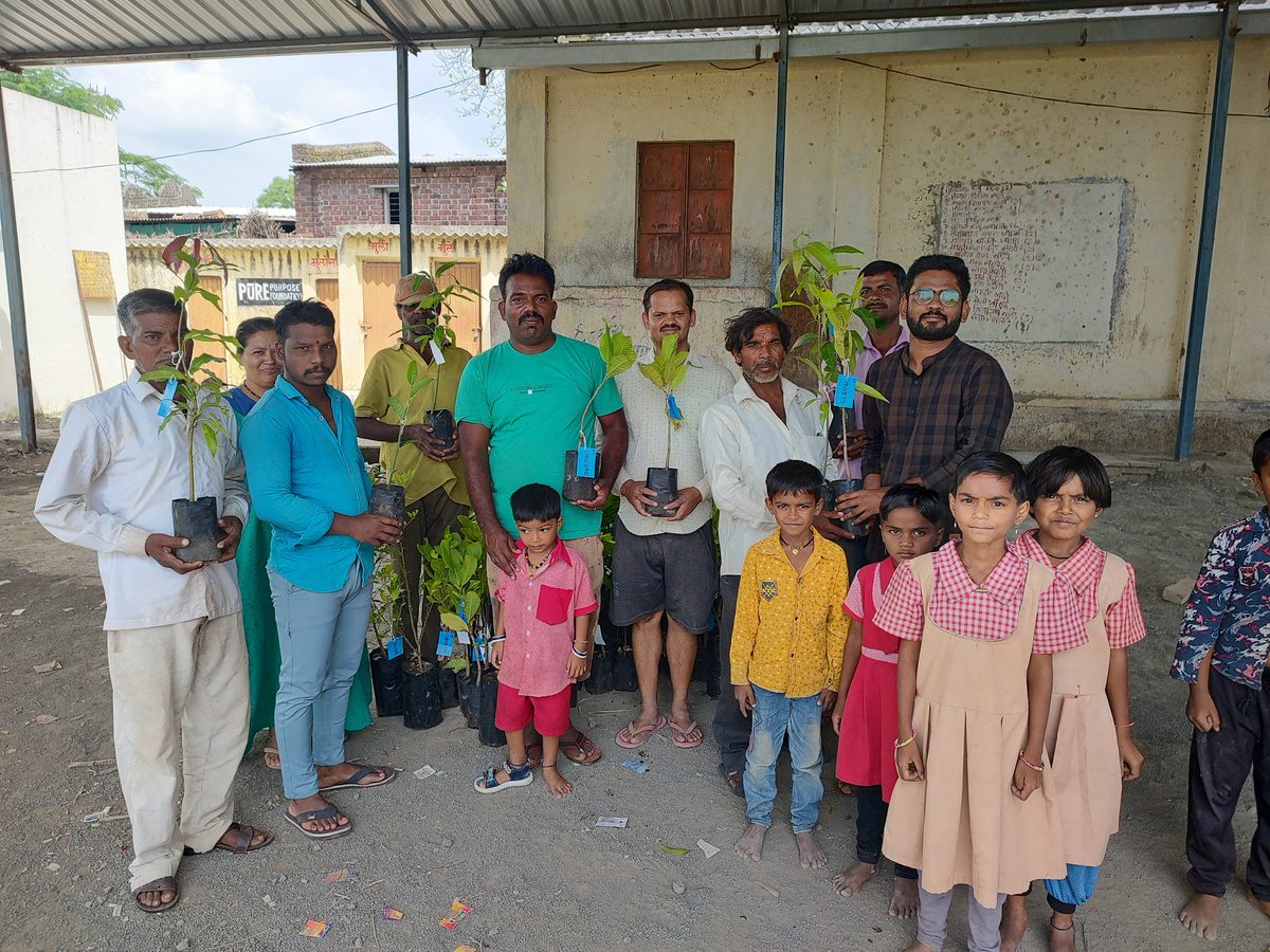 Community members and children holding saplings during a Swasth Paryavaran Mission tree-planting drive